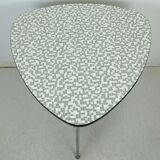 Table basse des années 1950 à trois pieds avec un plateau en formica et des pieds en chrome inclinés.