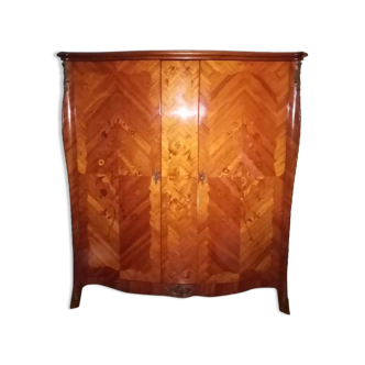 Armoire de style Louis XV en marqueterie de bois précieux pieds cambrés chaussés de sabot.