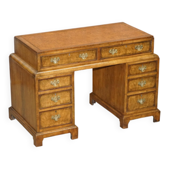 Curved pedestal desk in veined walnut, leather surface, late Victorian period.