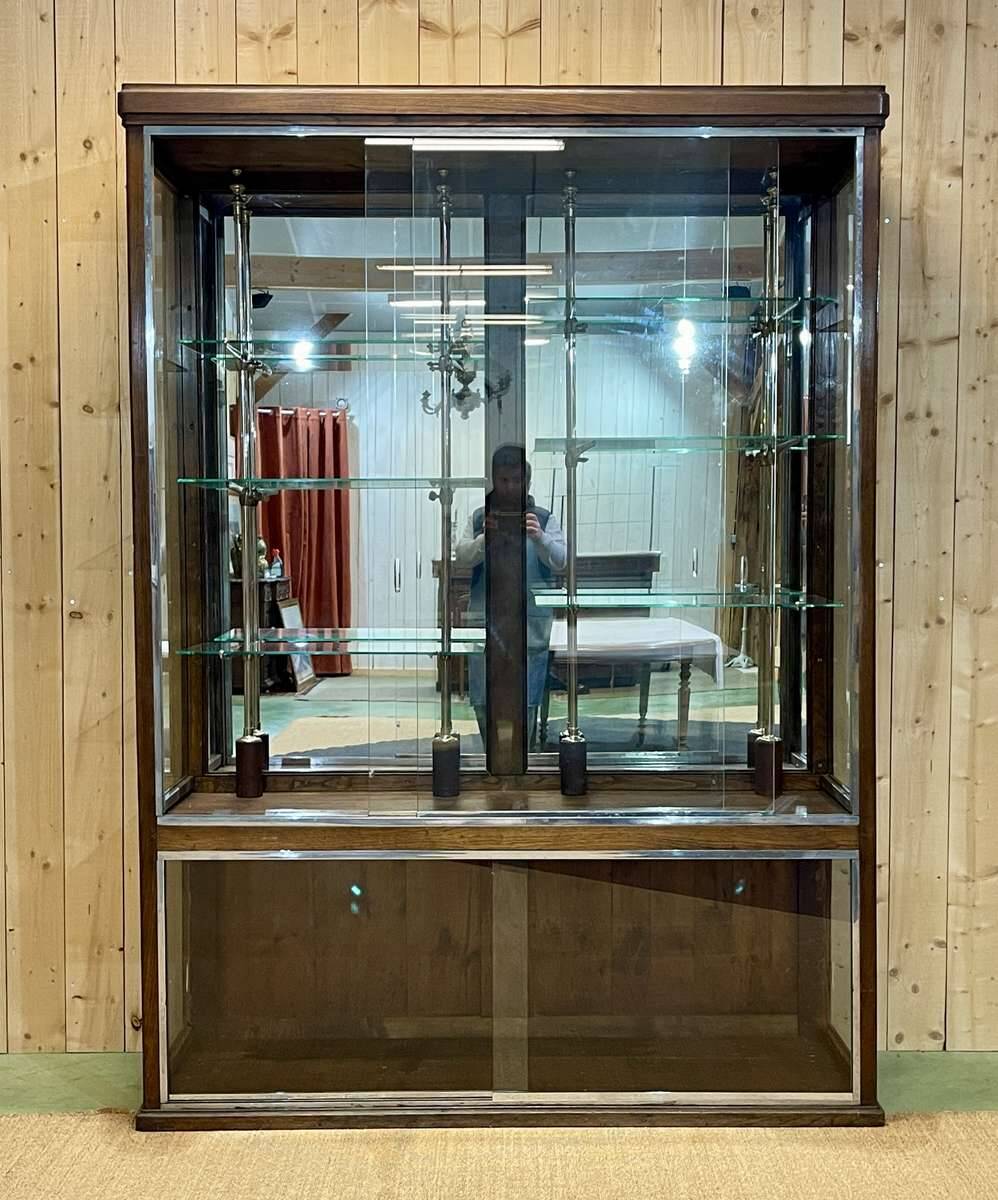 Early 20th-century shop display cabinet in oak with sliding doors.