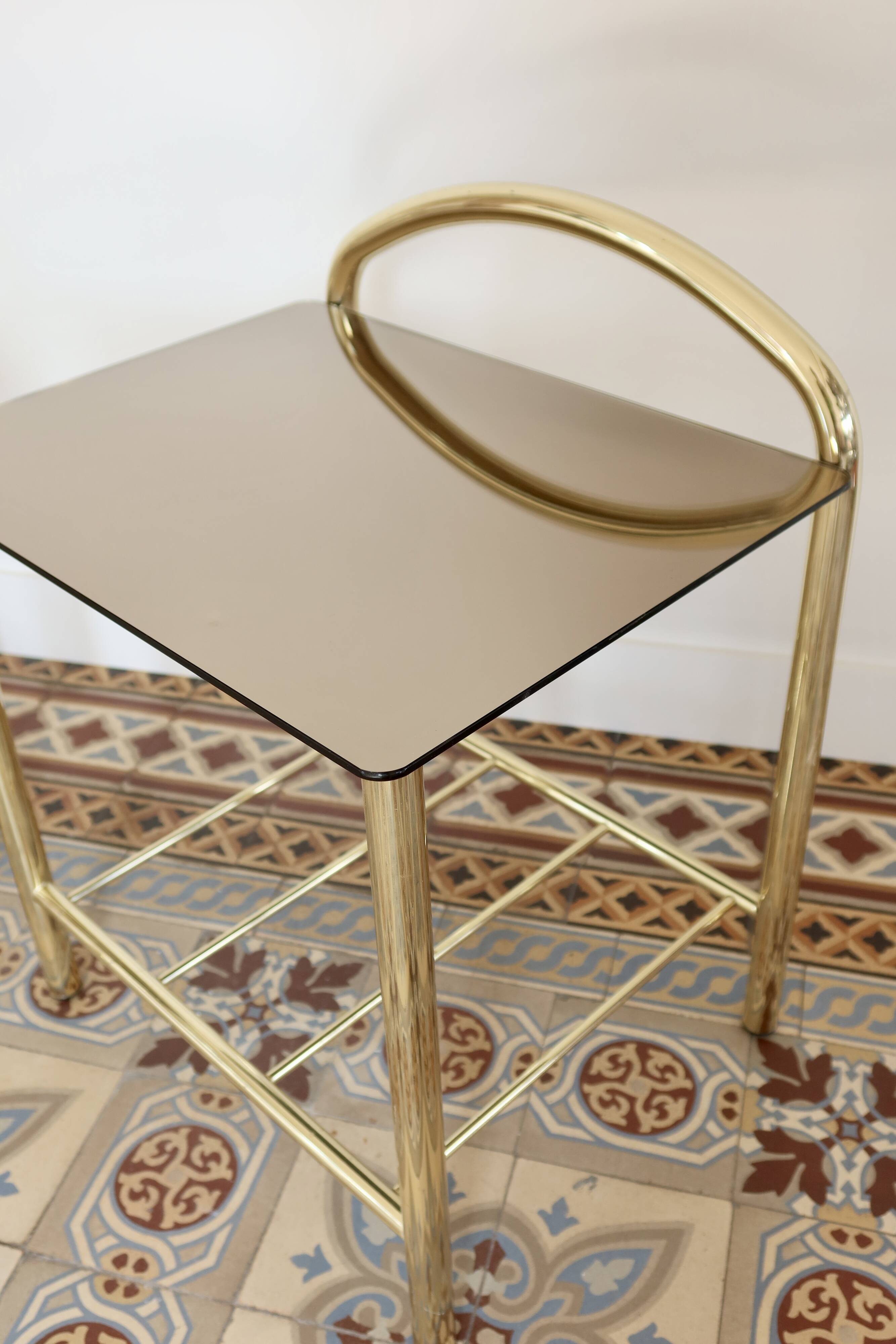 Pair of bedside tables with gold metal and mirrored glass top.