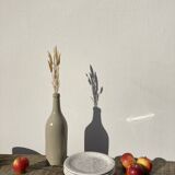 4 black speckled dessert plates on a vintage white background