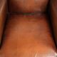 Sheepskin wingback armchair finished with black piping and a correct seat
