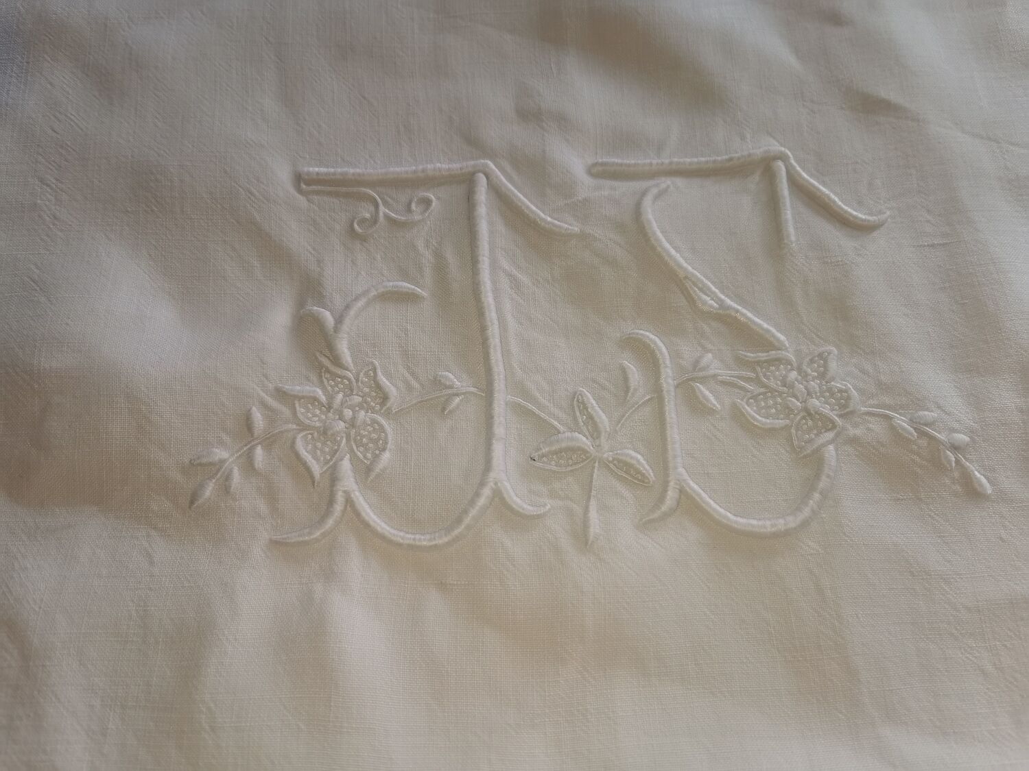 Antique embroidered linen sheet with a monogram.