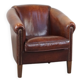 Sheepskin club armchair, correct finishing with decorative nails