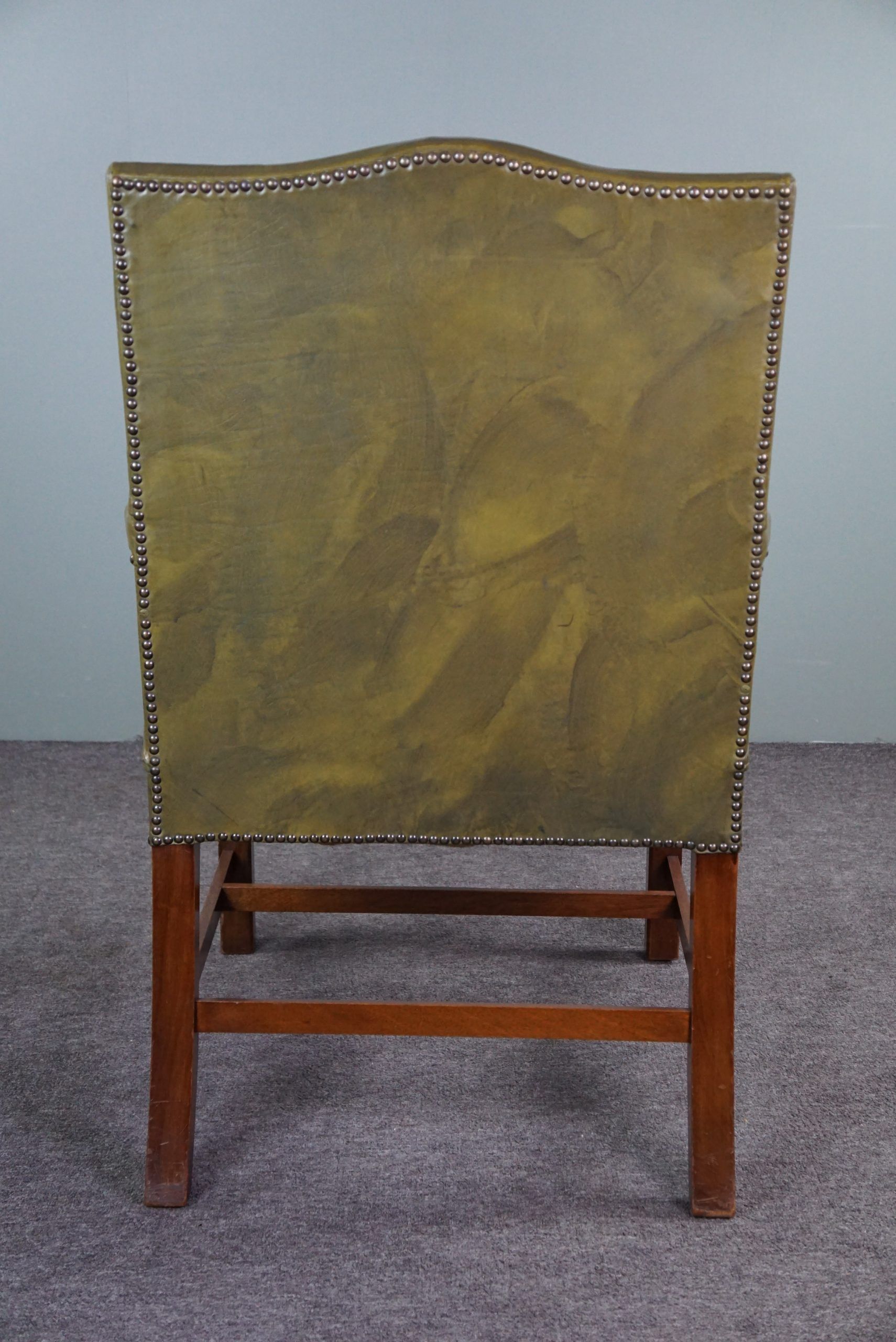 Elegant armchair and footrest in English green leather