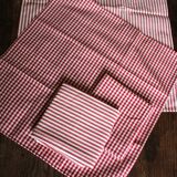 A set of 4 red striped and checkered napkins.