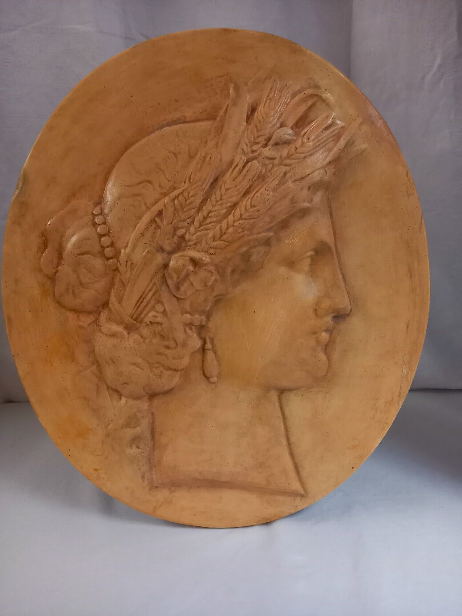 Plaster medallion, high relief, yellow ochre patina, representing the Roman divinity Ceres