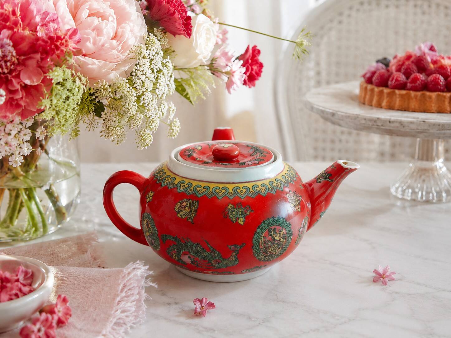 Vintage red Chinese teapot decorated with dragons and symbols.