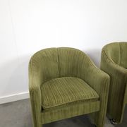 Chaises de cocktail vertes avec des roues chromées.