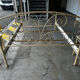 Patinated metal and wood double bed with integrated bedside tables.