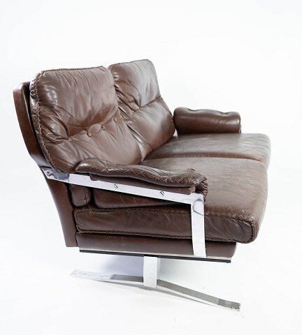 Two seater sofa upholstered with patinated brown leather and frame in metal, designed by Arne Norell