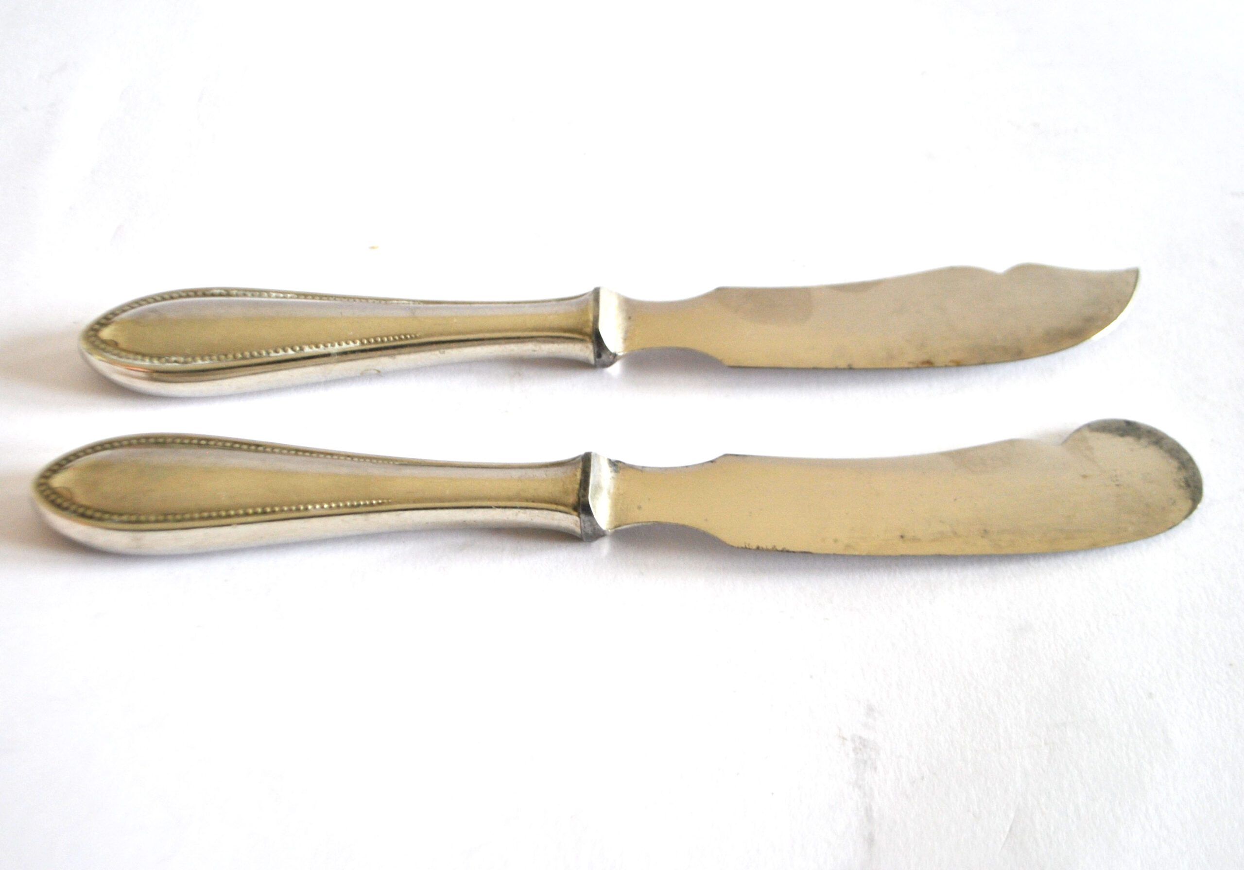 Two antique service knives in silver-plated metal, pearl frieze gowe alpacca.