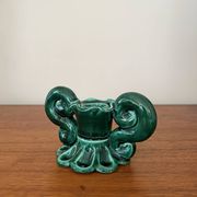 Green ceramic candlestick with curled handles.
