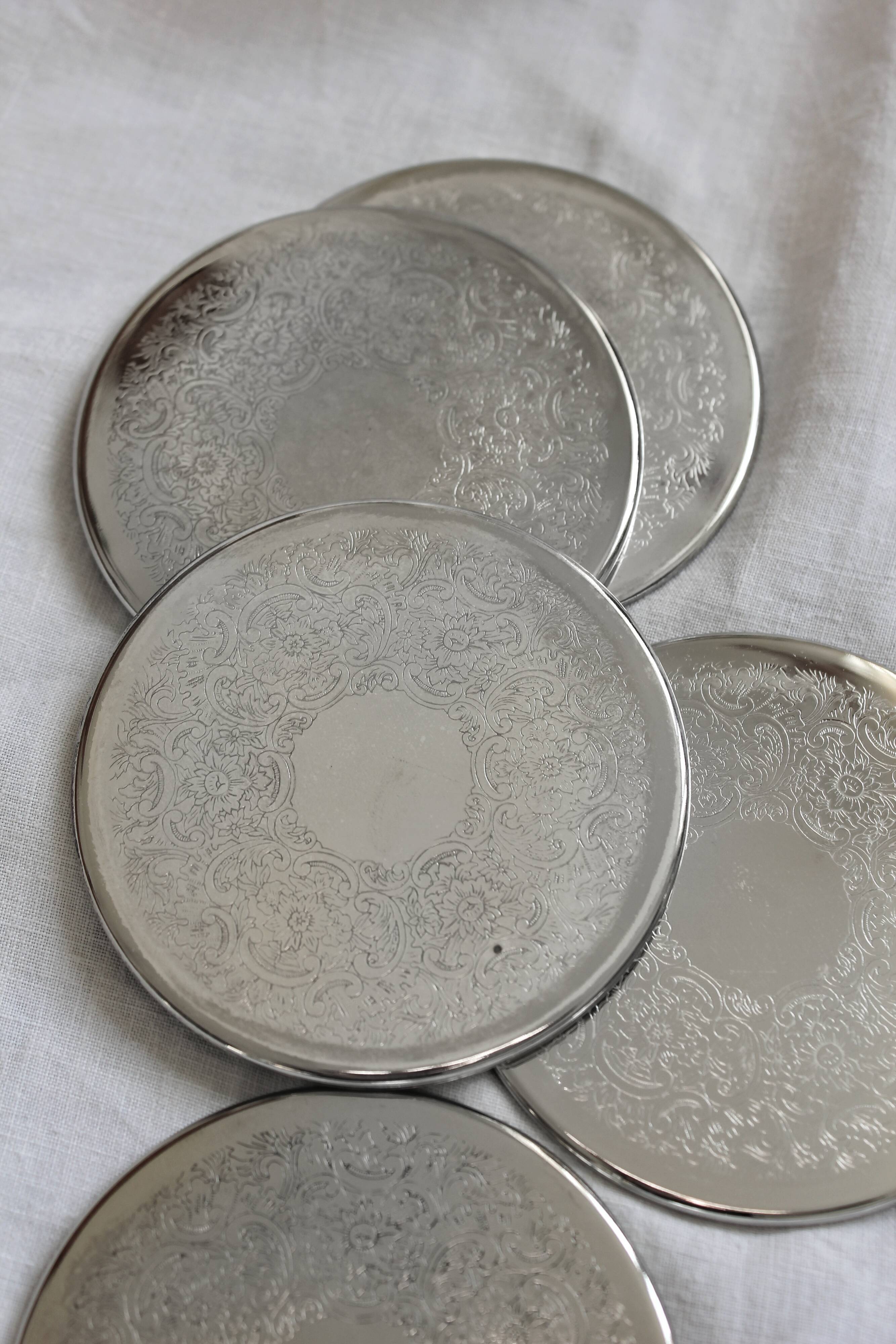 6 vintage chiseled silver metal coasters