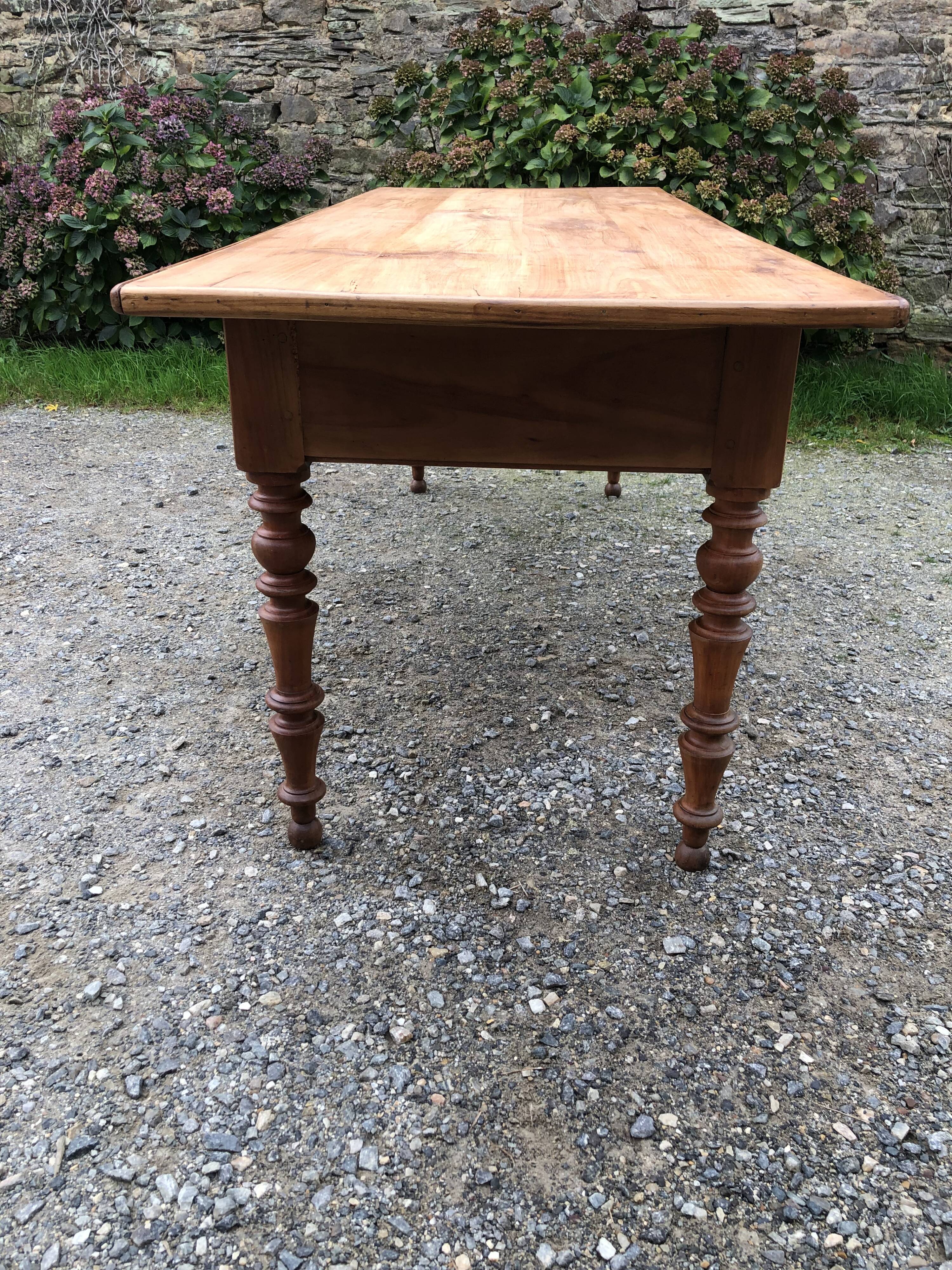 Antique Louis Philippe style farm table in solid cherry wood with 2 drawers and turned base.
