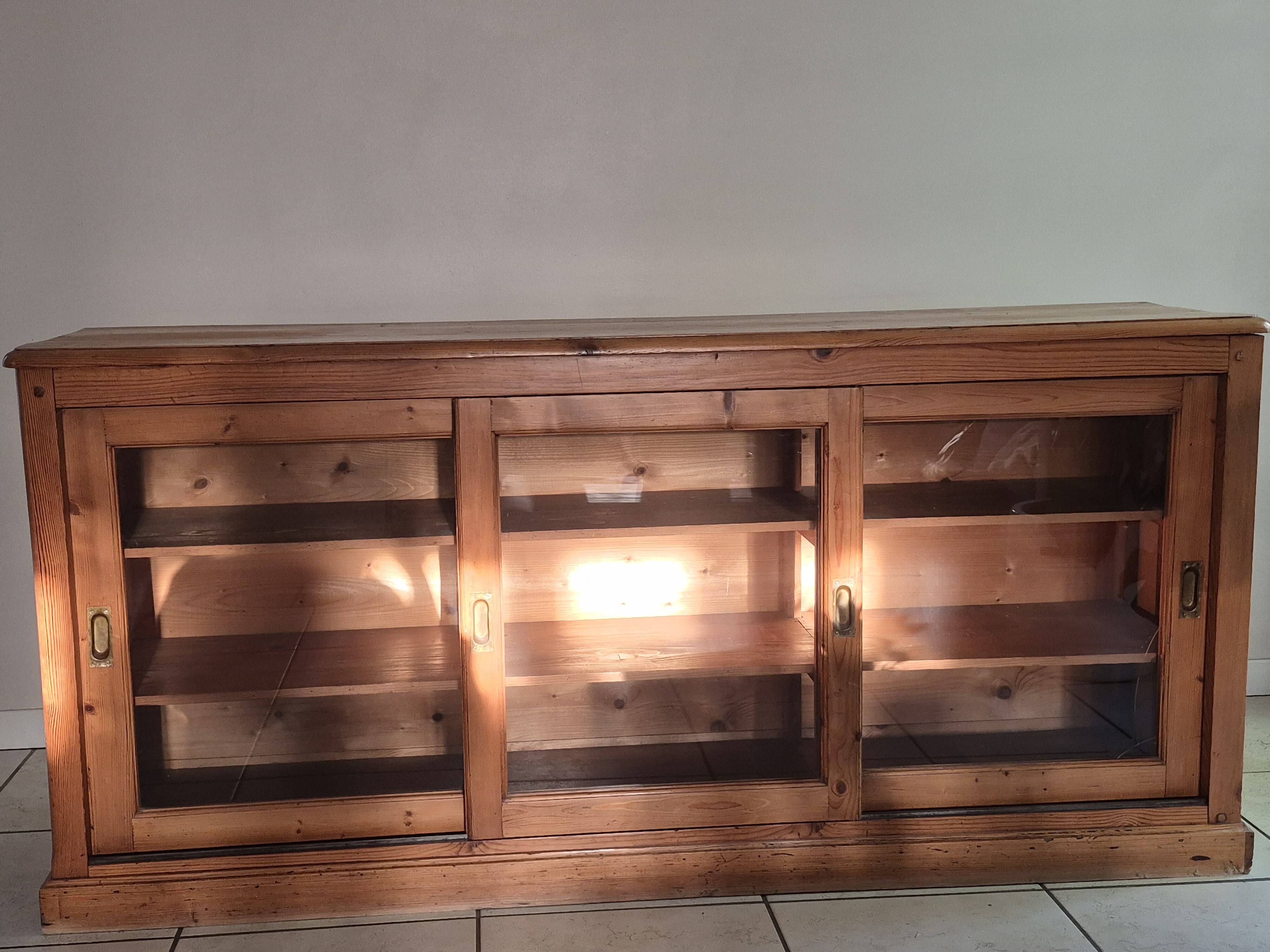 Antique wooden sideboard with three sliding glass doors.