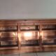 Antique wooden sideboard with three sliding glass doors.
