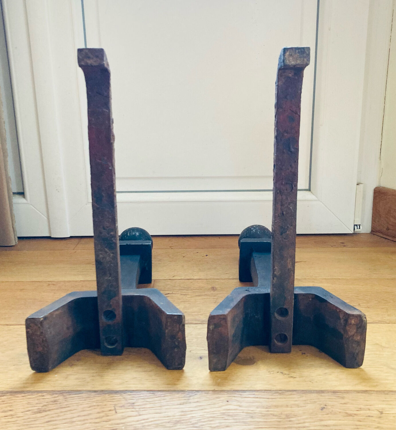 Pair of massive antique-style fire dogs in solid iron from the 20th century.