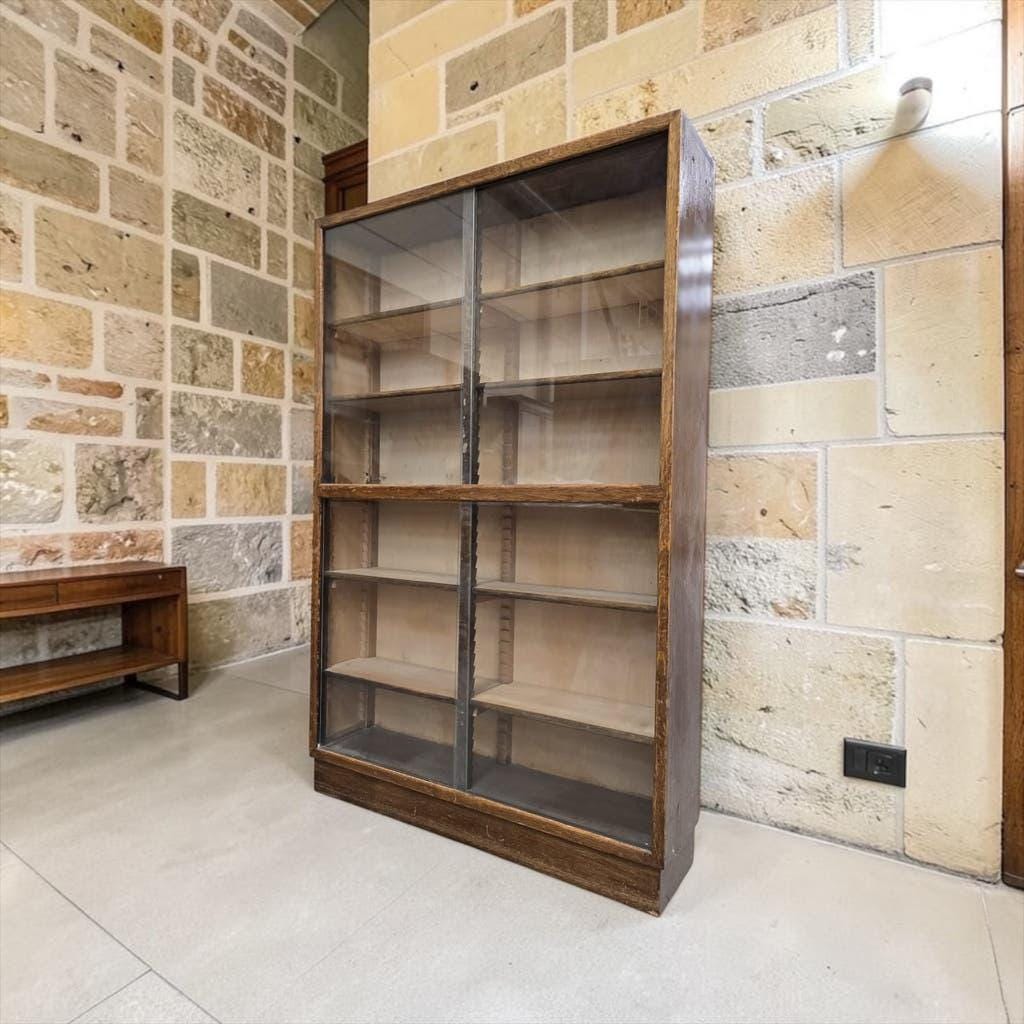 Vintage shallow wooden display shelf with sliding glass doors.