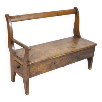 Banc artisanal en bois avec accoudoir et tiroir à droite.