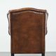 Sheepskin wingback armchair with decorative nails and black piping