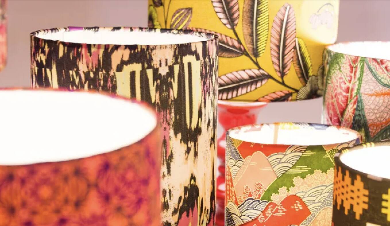 Lampshade covered with a decorative translucent fabric featuring a peacock pattern.