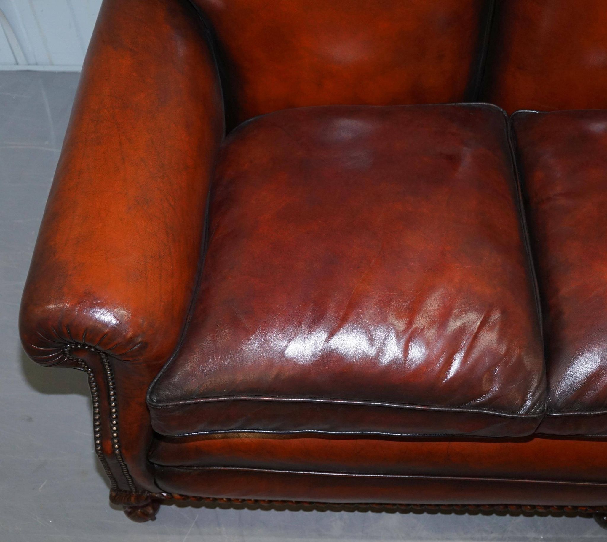 Restored Victorian sofa in leather with claw feet and feather cushions.