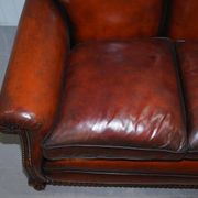 Restored Victorian sofa in leather with claw feet and feather cushions.