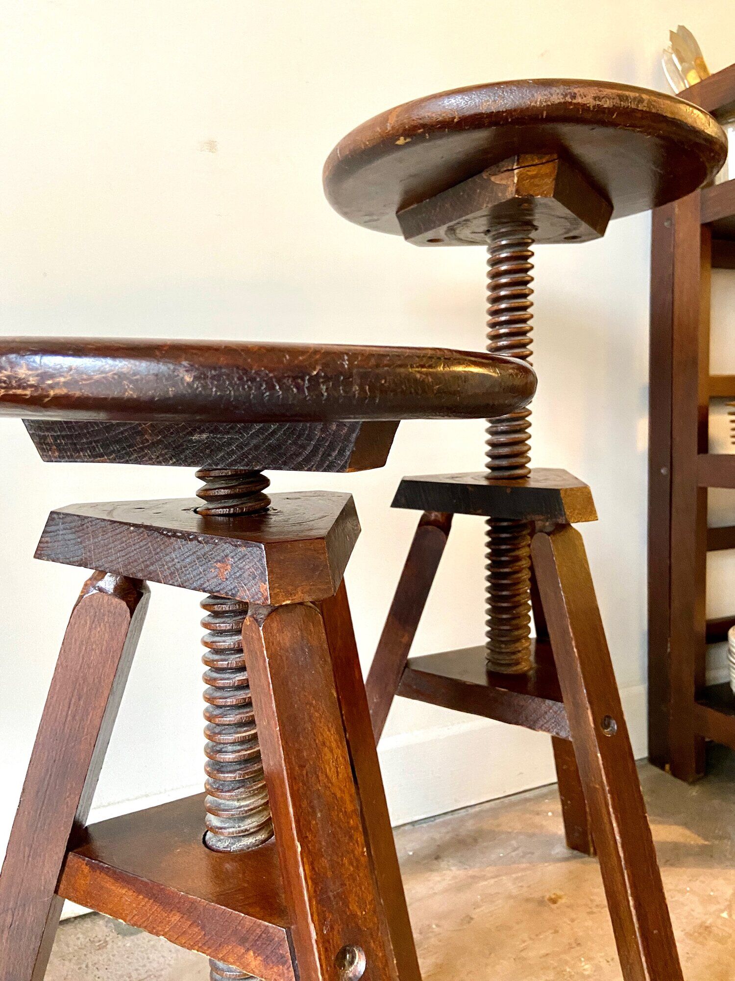 2 tripod stools with dark wood screws