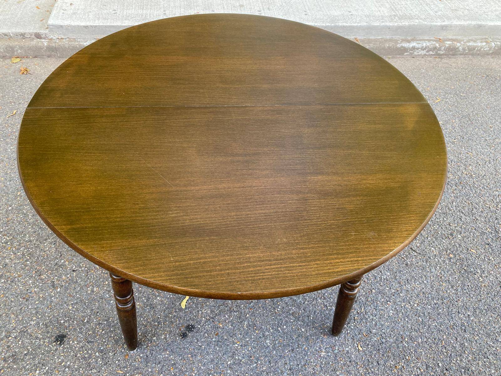 Extendable round table in solid wood with a dark oak satin finish.