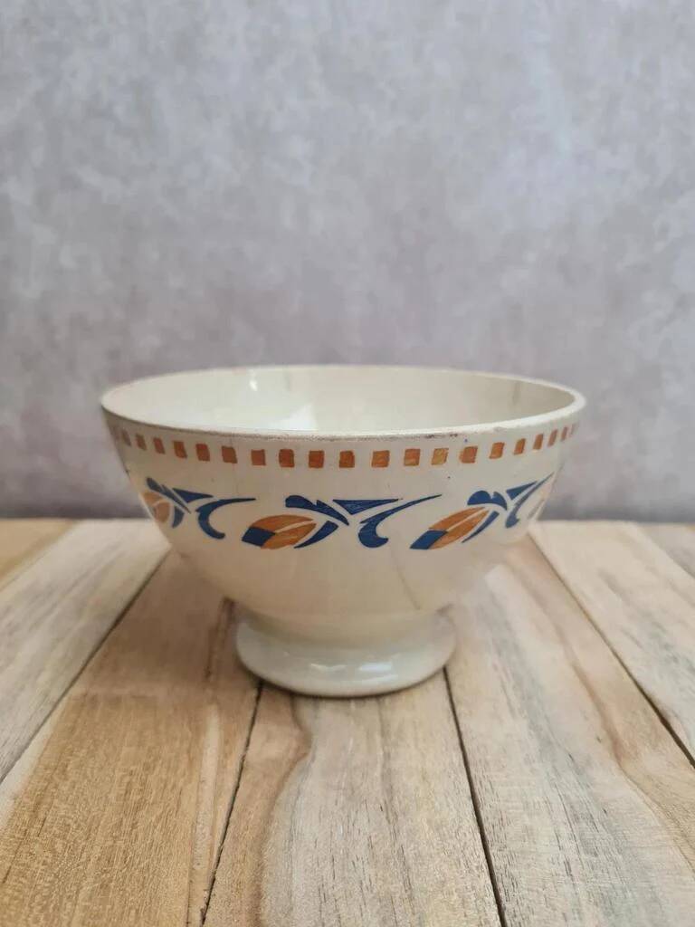 Old ironstone bowl with vintage blue and ochre decoration.