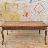 Curved farmhouse table in rustic wood, Provençal style.