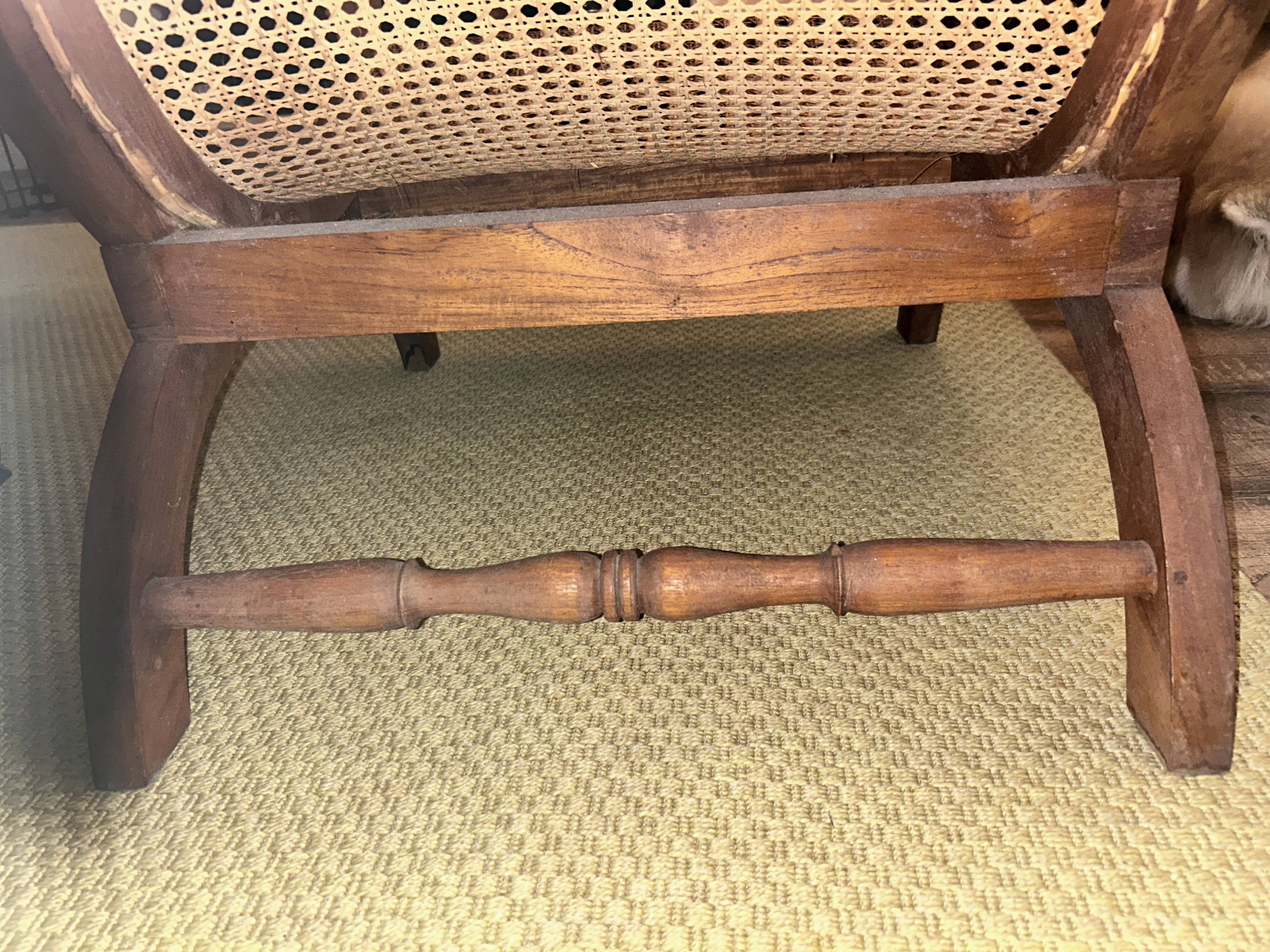 Colonial planter's armchair in solid teak, scroll armrests, caned seat.