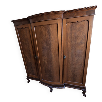 Large English-style wardrobe with a curved front and three doors.
