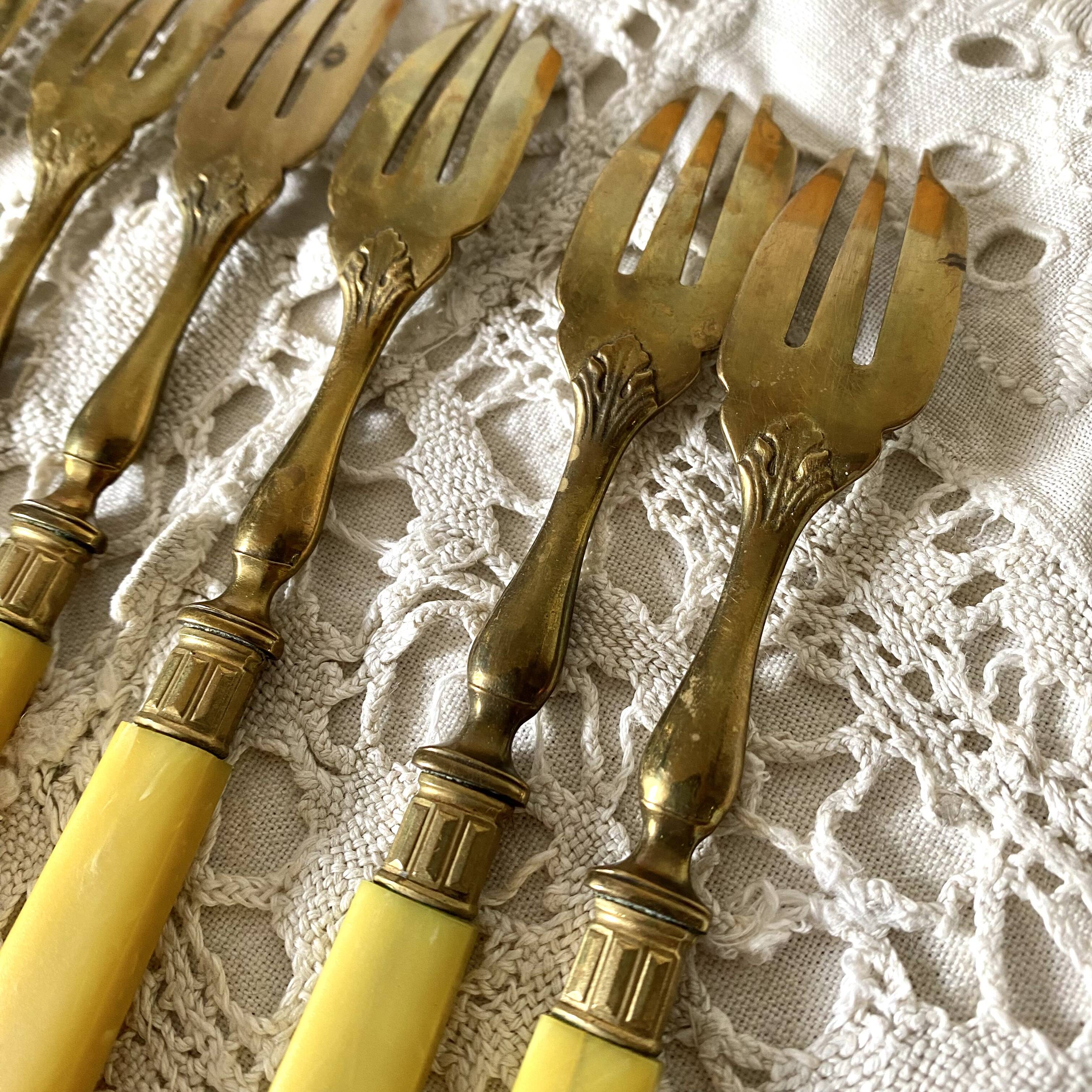Antique dessert forks in brass and bakelite