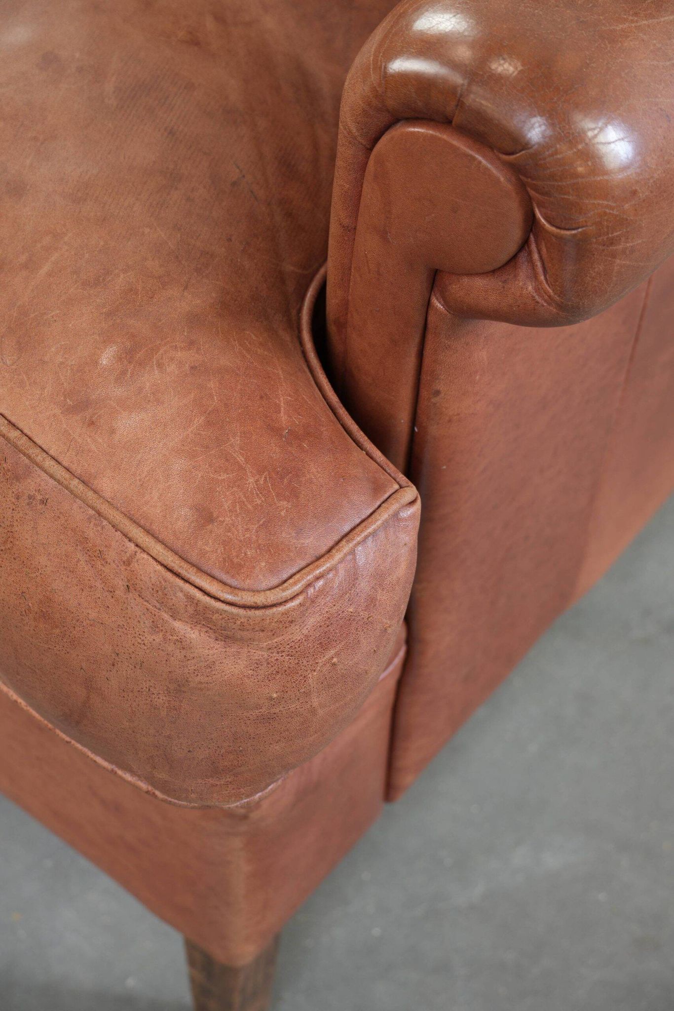 Light cognac-coloured English wingback armchair made of cowhide leather