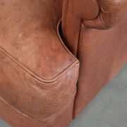 Light cognac-coloured English wingback armchair made of cowhide leather