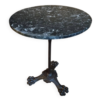 Old French bistro table with a marble top and a cast iron base.