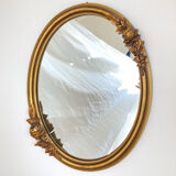 Oval mirror with a gilded frame and carved with bouquets of roses
