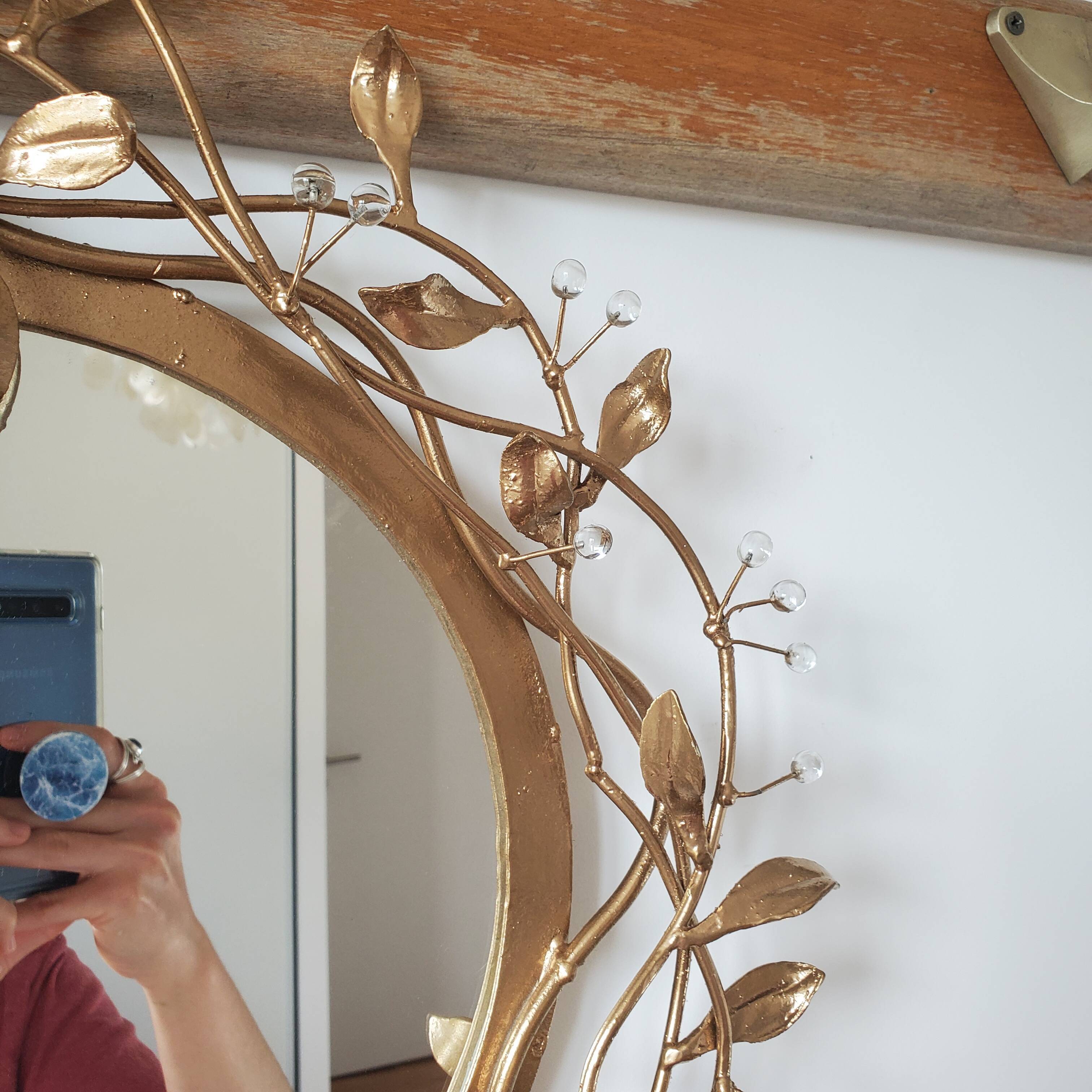 Round mirror in gilded wrought iron and leaves