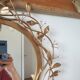 Round mirror in gilded wrought iron and leaves