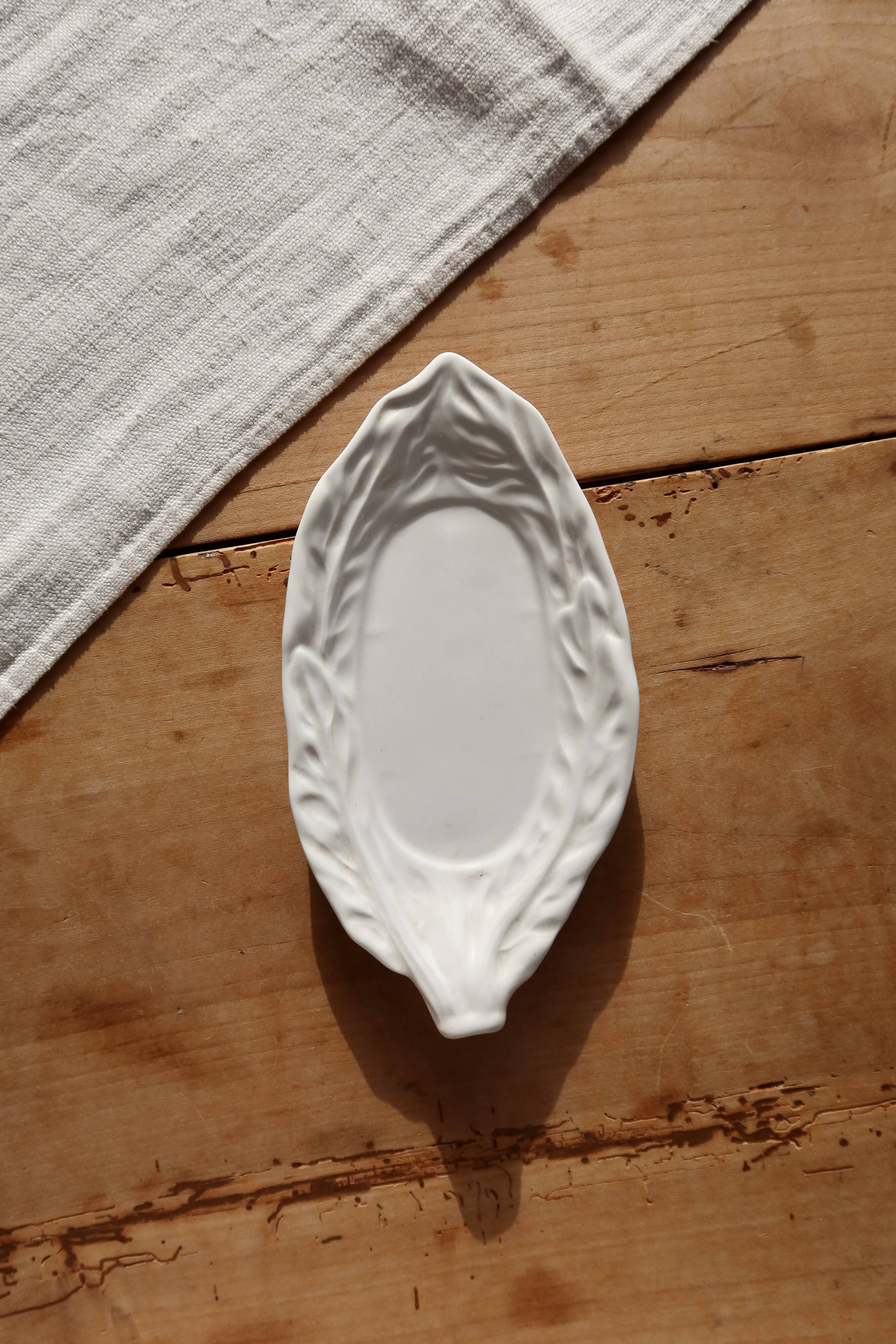 Antique leaf-shaped white English slipware dish.