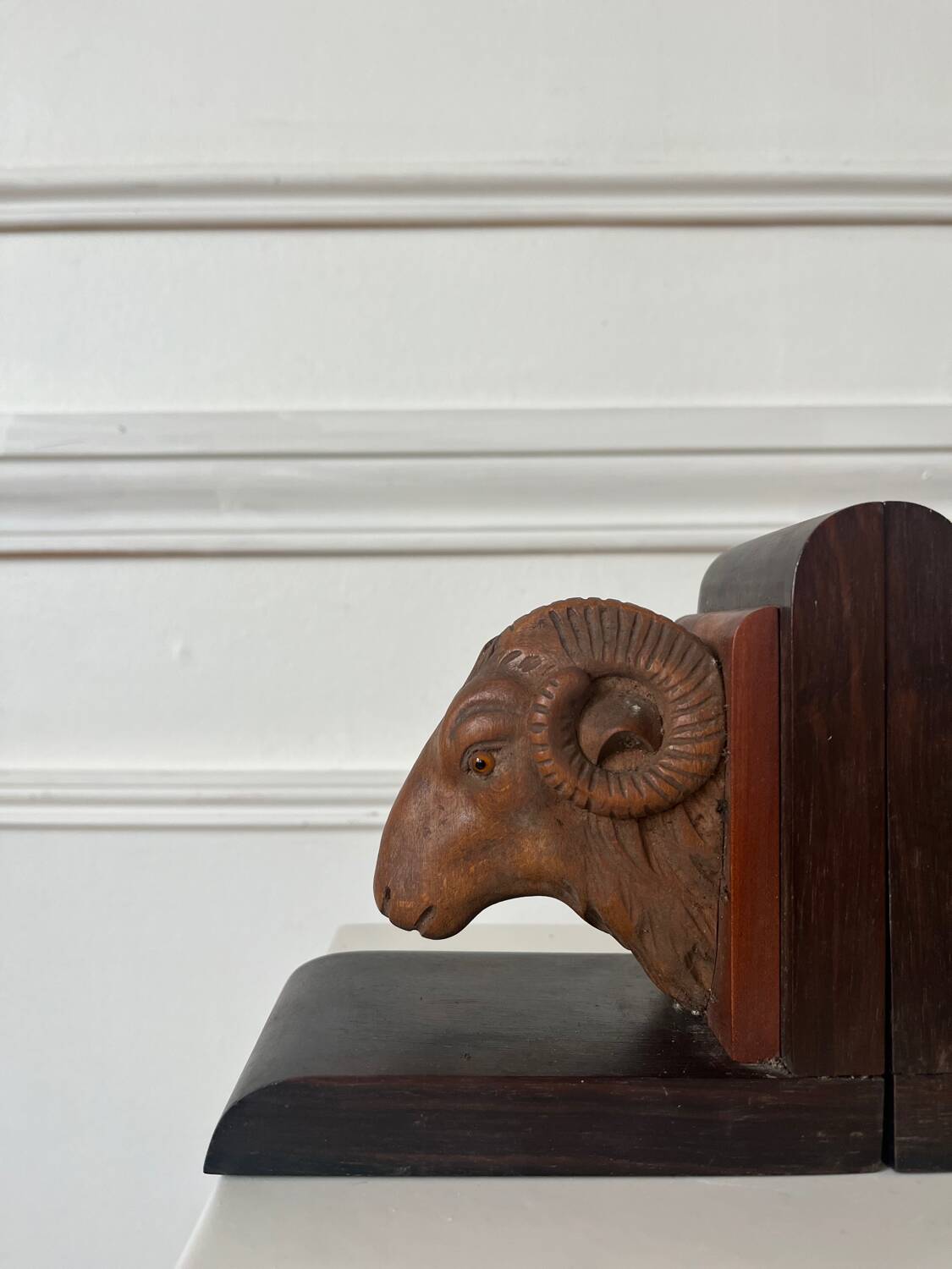Pair of carved wooden bookends in the shape of ram's heads.