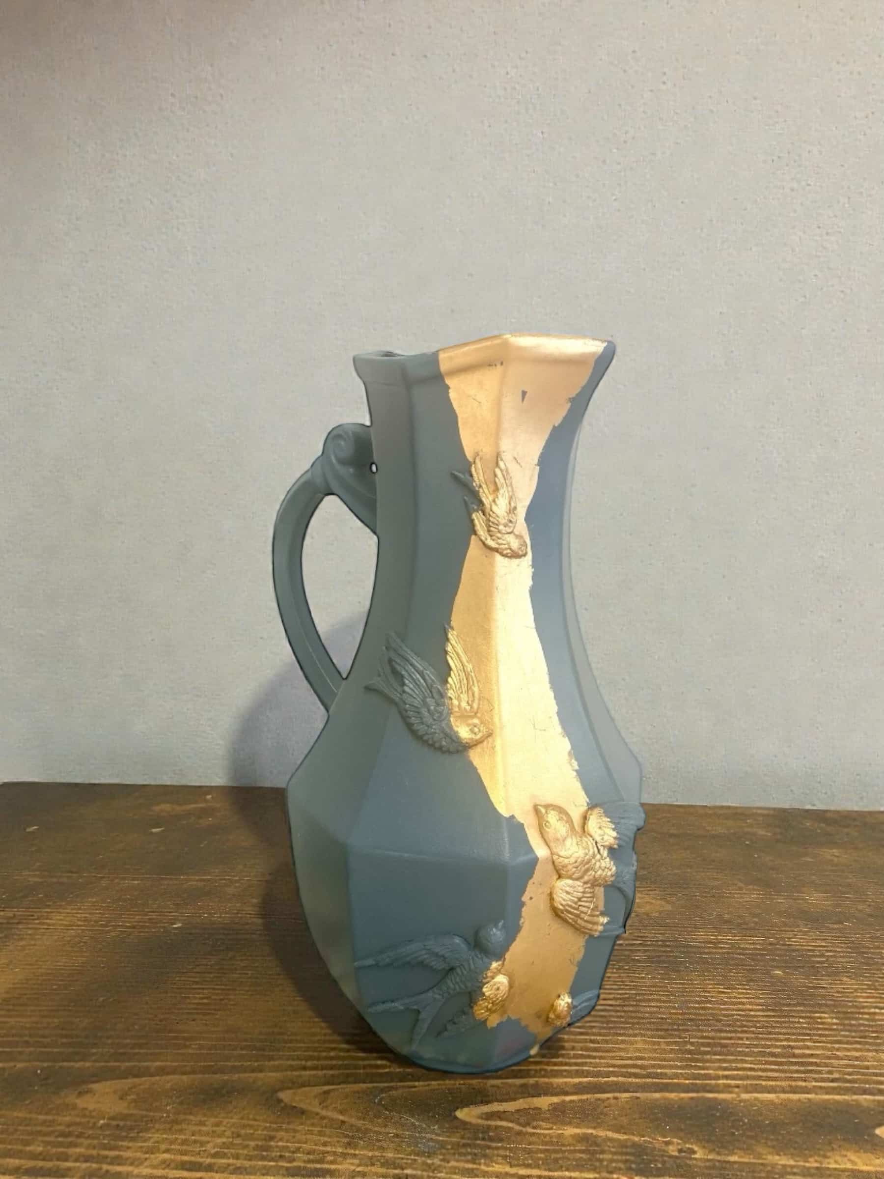 Large decorative blue-grey pitcher with swallow mouldings and gold leaf.