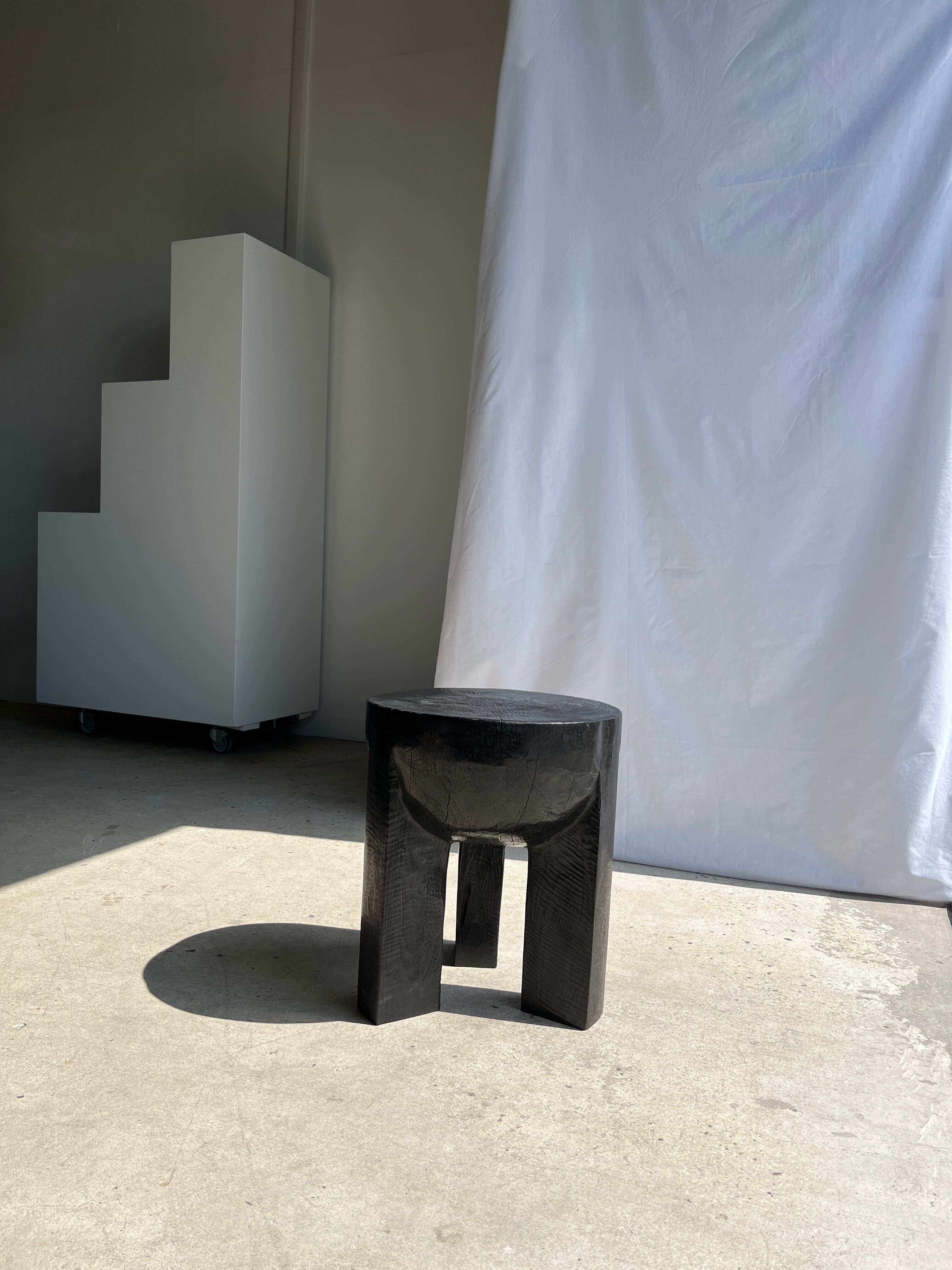 Black mango wood tripod side table with a semi-spherical top, height: 45 cm, diameter: 44 cm.