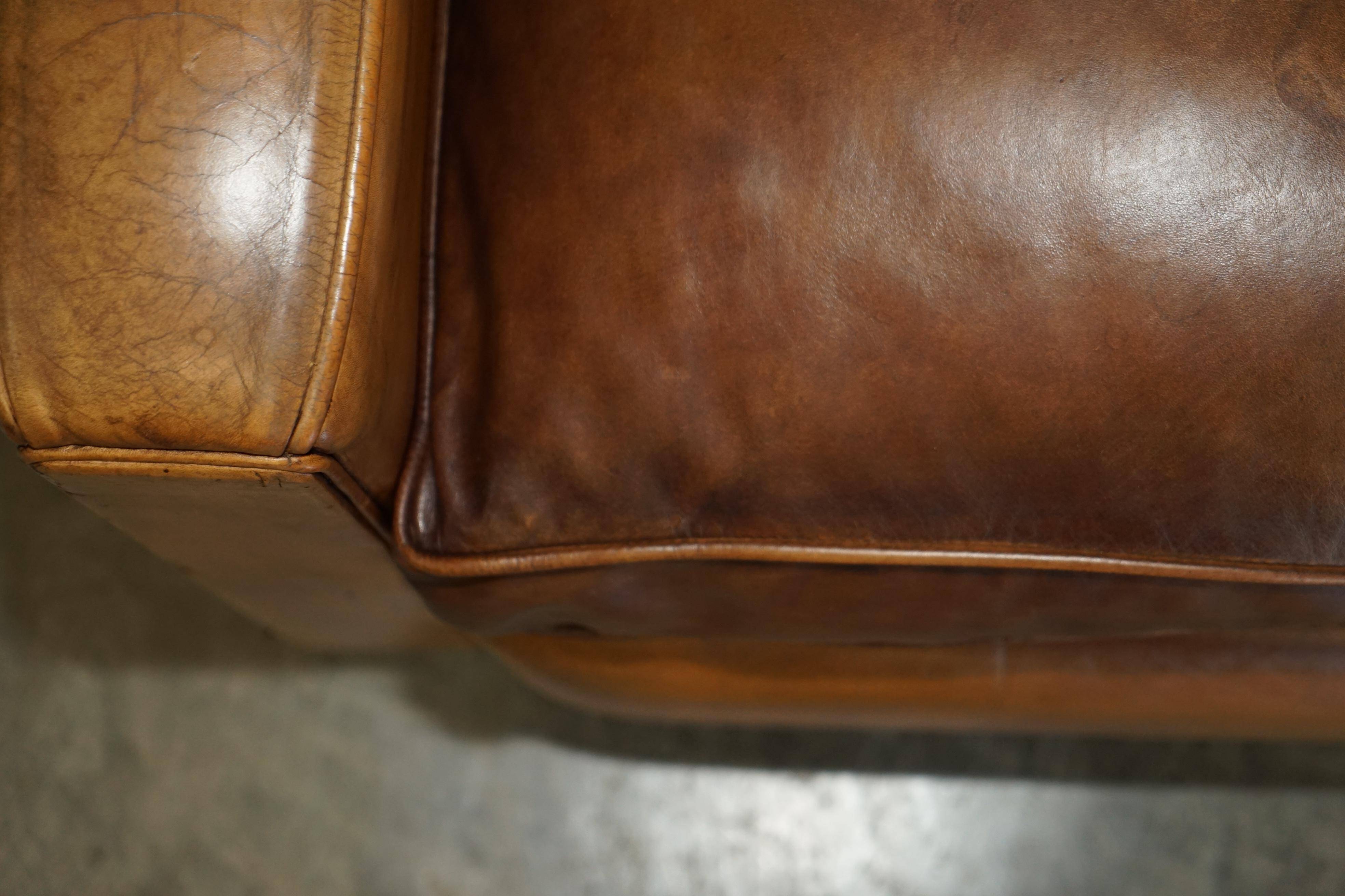 Three-seater Art Deco style leather sofa with feather cushions.