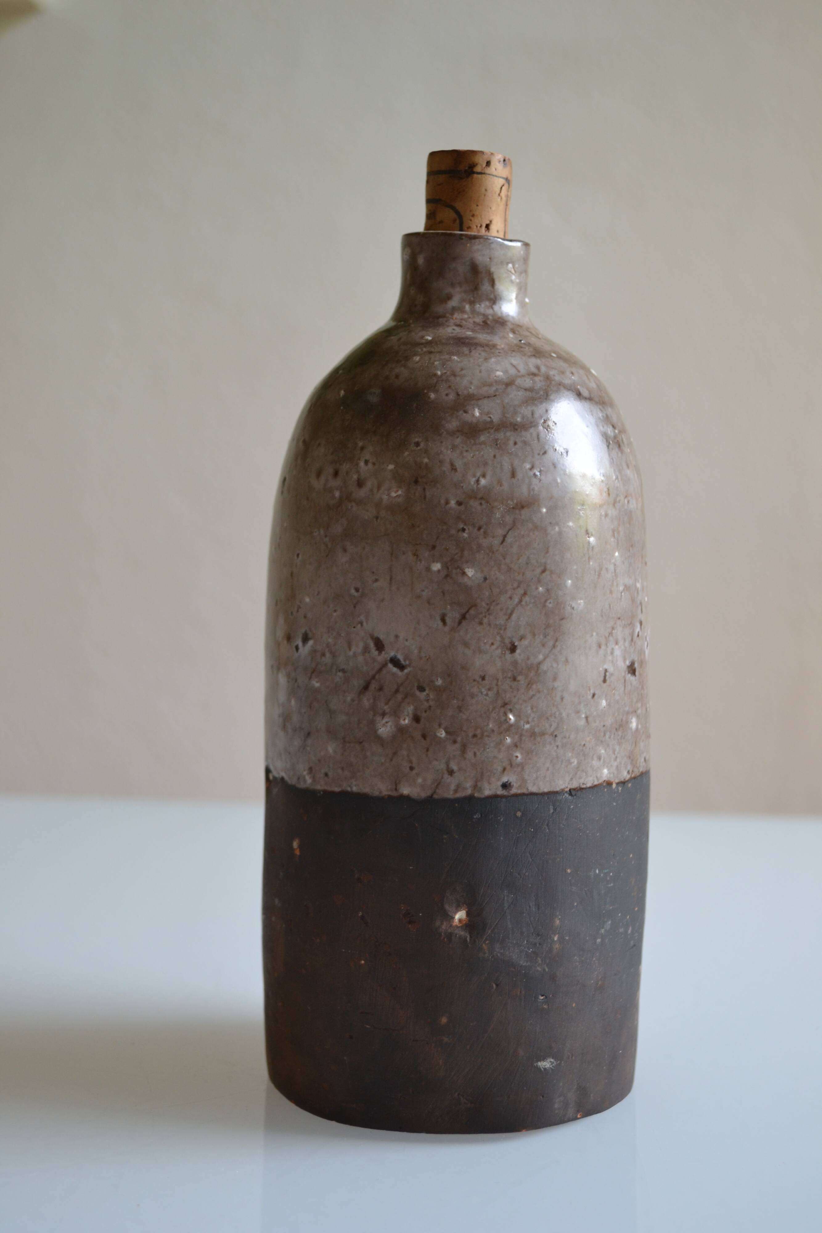 Ceramic bottle vase with a fish signature to be identified.