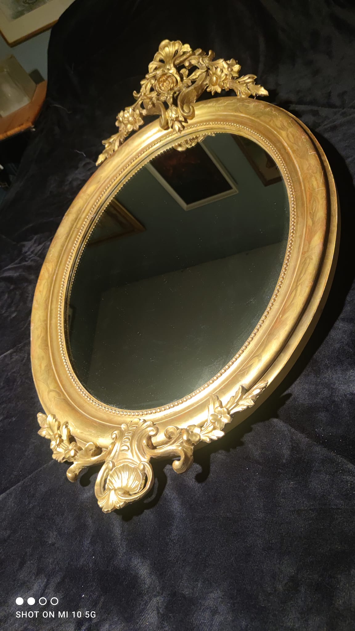 Ovoid mirror with double gilt pediments, circa 1830, 105x66 cm