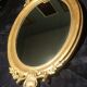 Ovoid mirror with double gilt pediments, circa 1830, 105x66 cm